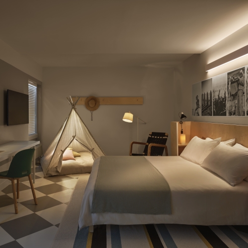 Hotel room with a king bed and a teepee set up for kids