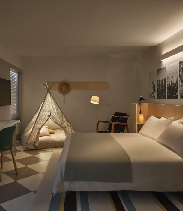 Hotel room with a king bed and a teepee set up for kids